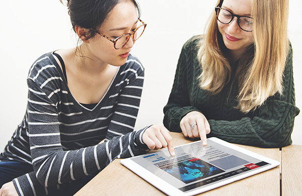 Two women using a tablet to access the internet